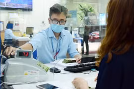 Giao dịch tại ngân hàng. (Ảnh: Vietnam+)