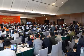 Phóng viên tác nghiệp nghiêm túc và khẩn trương tại Trung tâm báo chí Đại hội lần thứ XIII của Đảng. (Ảnh: TTXVN)