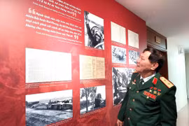 Trung tướng Phạm Tuân nhìn lại hình ảnh của chính mình trong trân chiến 50 năm trước. (Ảnh: Minh Thu/Vietnam+)
