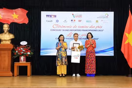 Tổng giám đốc TTXVN Vũ Việt Trang (bìa phải) và Quyền Trưởng đại diện Tổ chức quốc tế Pháp ngữ khu vực Châu Á-Thái Bình Dương Trần Thị Mai Yến trao giải Nhất cho thí sinh Hồ Ngọc Vĩnh Nguyên. (Ảnh: Tuấn Anh/TTXVN)