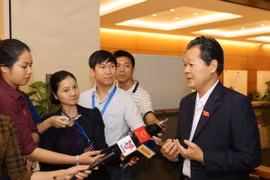 Phóng viên phỏng vấn đại biểu Quốc hội bên lề một phiên họp của Kỳ họp thứ hai, Quốc hội khóa XIV. (Ảnh: Phương Hoa/TTXVN)