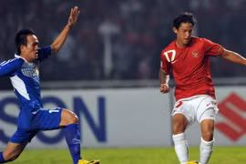 Tiền đạo Irfan Bachdim (phải), đội Indonesia trong pha tranh bóng với cầu thủ Kovanh Namthavixay, đội Lào. (Ảnh: AFP/TTXVN)