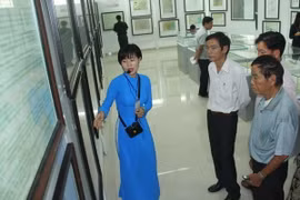 Du khách đến tham quan, tìm hiểu về các hiện vật, bản đồ trưng bày tại triển lãm. (Ảnh: Bùi Như Trường Giang/TTXVN)