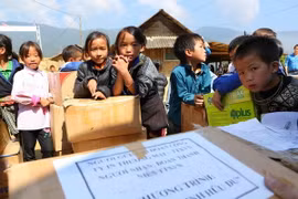 Học sinh trường Phổ thông Dân tộc bán trú Tiểu học và THCS Chế Tạo (xã Chế Tạo, huyện Mù Cang Chải) đón nhận những phần quà "Tủ sách Đinh Hữu Dư" của Đoàn thanh niên TTXVN trao tặng. (Ảnh: Thành Đạt/TTXVN)