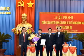 Phó Ban Tổ chức Trung ương Hà Ban, Bí thư Tỉnh ủy Hà Giang Triệu Tài Vinh và Bí thư Thứ nhất Trung ương Đoàn TNCS Hồ Chí Minh trao quyết định và tặng hoa chúc mừng Tân Phó Bí thư Tỉnh ủy Hà Giang Nguyễn Mạnh Dũng. (Ảnh: Minh Tâm/TTXVN.)