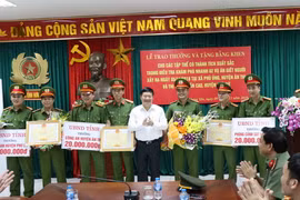Chủ tịch Ủy ban Nhân dân tỉnh Hưng Yên Nguyễn Văn Phóng trao tiền thưởng và bằng khen cho đại diện các lực lượng phá án 2 vụ giết người. (Ảnh: Đinh Tuấn/TTXVN)