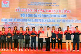 Ông Bùi Quang Cẩm, Phó chủ tịch UBND tỉnh Hà Nam trao giấy khen và số tiền thưởng 200 triệu đồng từ quỹ khen thưởng Ủy ban Nhân dân tỉnh Hà Nam cho đội bóng Phong Phú Hà Nam. (Ảnh: Đại Nghĩa/TTXVN)