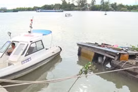 Lực lượng chức năng Đồng Nai bảo vệ hiện trường phối hợp với các đơn vị bơm hút hóa chất bị chìm dưới sông tránh nguy cơ tràn hóa chất. (Ảnh: Sỹ Tuyên/TTXVN)