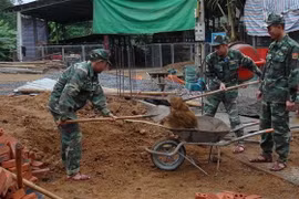Các chiến sỹ Đồn Biên phòng Mường Cai giúp đồng bào vùng biên xây nhà. (Ảnh: Hữu Quyết/TTXVN)