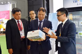 Thứ trưởng Nông nghiệp Trần Thanh Nam (trái) và Thứ truởng Công thương Đỗ Thắng Hải (giữa) tham quan gian hàng TH Truemilk. (Ảnh: Anh Tuấn/TTXVN)