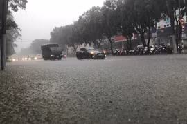 Nhiều tuyến đường ngập nước khiến phương tiện tham gia giao thông gặp nhiều khó khăn tại thành phố Vinh. (Ảnh: Bích Huệ/TTXVN)