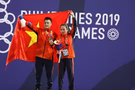 Lại Gia Thành (bên phải) và Vương Thị Huyền (cử tạ nữ) ăn mừng chiến thắng. (Ảnh: Hoàng Linh/TTXVN)