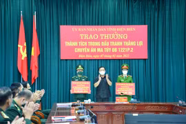 Phó Chủ tịch UBND tỉnh Điện Biên Vừ A Bằng trao Bằng khen của UBND tỉnh Điện Biên cho các lực lượng tham gia phá án. (Ảnh: TTXVN)