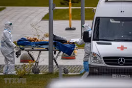 Nhân viên y tế chuyển bệnh nhân COVID-19 vào bệnh viện Kommunarka ở ngoại ô Moskva, Nga ngày. (Ảnh: AFP/TTXVN) 