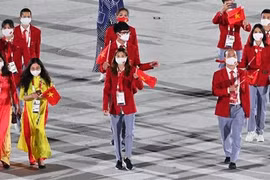 Đoàn thể thao Việt Nam diễu hành tại lễ khai mạc Olympic Tokyo 2020 trên sân vận động Olympic ở Tokyo (Nhật Bản), ngày 23/7/2021. (Ảnh: AFP/TTXVN) 