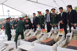 Nguyên Chủ tịch nước Trương Tấn Sang và lãnh đạo tỉnh Hà Giang cùng các đại biểu dự lễ an táng hài cốt liệt sỹ tại Nghĩa trang Liệt sỹ Quốc gia Vị Xuyên. (Ảnh: Minh Tâm/TTXVN)