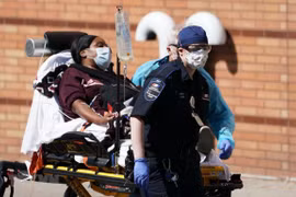 Nhân viên y tế chuyển bệnh nhân mắc COVID-19 vào một bệnh viện ở New York, Mỹ. (Ảnh: AFP/TTXVN)