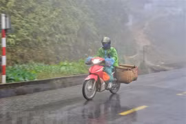 Người dân đi xe máy vận chuyển hàng hóa trong sương sớm, giá lạnh trên đỉnh đèo Pha Đin, Điện Biên. (Ảnh: Xuân Tiến/TTXVN) 
