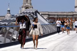 Một người phụ nữ che chắn dưới nắng nóng ở cầu Millennium, London, Anh hôm 18/7. (Ảnh: Reuters.)