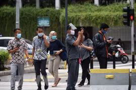 Người dân đeo khẩu trang phòng lây nhiễm COVID-19 tại Jakarta, Indonesia. (Ảnh: THX/TTXVN) 