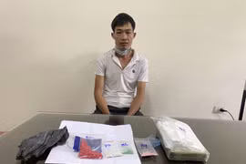 Đối tượng Hoàng Văn Thoa cùng tang vật. (Ảnh TTXVN)