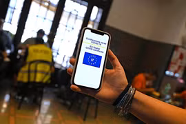 Kiểm tra chứng nhận tiêm vaccine phòng COVID-19 của khách hàng tại một nhà hàng ở Rome, Italy, ngày 6/8/2021. (Ảnh: AFP/ TTXVN)