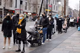 Người dân xếp hàng chờ lấy mẫu xét nghiệm COVID-19 tại London, Anh. (Ảnh: AFP/TTXVN)