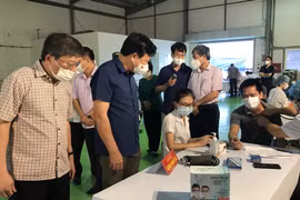 Bí thư Tỉnh ủy Hải Dương Phạm Xuân Thăng kiểm tra công tác khám sàng lọc trước khi tiêm. (Ảnh: Tiến Vĩnh/TTXVN)