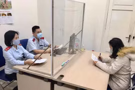 Thanh tra Sở Thông tin và Truyền thông Hà Nội làm việc với chị Hoàng Thu Trang. (Ảnh: TTXVN phát)