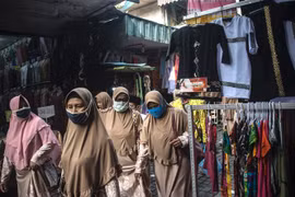 Người dân đeo khẩu trang phòng lây nhiễm COVID-19 tại Surabaya, Indonesia, ngày 17/3/2021. (Ảnh: AFP/TTXVN)