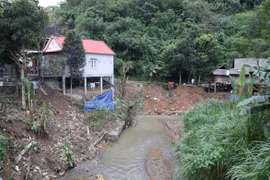 Cụm dân cư nằm trong khu vực có nguy cơ sạt lở, sụt trượt cao khi người dân xây dựng nhà ở bên bờ vực hạ nguồn khe suối. (Ảnh: Xuân Tiến/TTXVN)