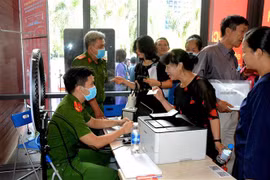 Công an làm căn cước công dân gắn chíp cho người dân tại điểm dịch vụ công trực tuyến. (Ảnh: Thành Chung/TTXVN)