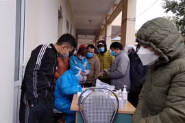 Công nhân chen nhau lấy mẫu xét nghiệm tại Trạm y tế phường Bình Minh, thị xã Nghi Sơn (Thanh Hóa). (Ảnh: Nguyễn Nam/TTXVN)