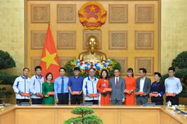 Phó Thủ tướng Vũ Đức Đam tặng quà cho các thầy cô trong buổi gặp mặt. (Ảnh: Minh Đức/TTXVN)