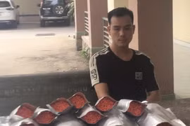 Đối tượng Ngô Mạnh Hoàng cùng tang vật vụ án. (Ảnh: TTXVN phát)