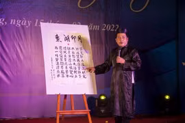 Dịch giả Trần Hót Lái giới thiệu nguyên tác chữ Hán bài thơ “Đông Hồ ấn nguyệt”, một tác phẩm xuất sắc trong chùm thơ Hà Tiên thập vịnh của Mạc Thiên Tích. (Ảnh: Hồng Đạt/TTXVN) 