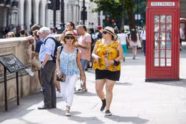 Người dân di chuyển trên đường phố dưới trời nắng nóng tại London, Anh, ngày 11/7/2022. (Ảnh: THX/TTXVN)