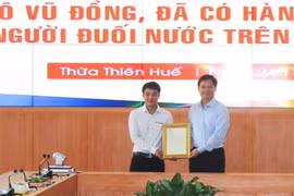Trao thư khen của Chủ tịch nước Nguyễn Xuân Phúc cho anh Tô Vũ Đồng. (Ảnh: Tường Vi/TTXVN)