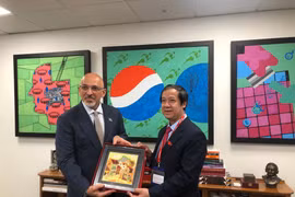 Bộ trưởng Nguyễn Kim Sơn tặng quà Bộ trưởng Nadhim Zahawi. (Ảnh: Minh Hợp/Vietnam+)