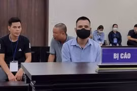 Bị cáo Việt (đeo khẩu trang, áo xanh) lừa đảo chạy vào ngành công an. (Nguồn: laodong.vn)