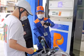 Người dân mua xăng dầu sau khi điều chỉnh giá mới tại một cửa hàng của Petrolimex. (Ảnh: Trần Việt/TTXVN)