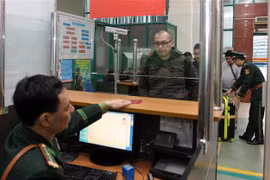 Cán bộ chiến sỹ Đồn Biên phòng cửa khẩu Quốc tế Lào Cai làm thủ tục nhập cảnh cho đoàn du khách nước ngoài vào Việt Nam. (Ảnh: Quốc Khánh/TTXVN)