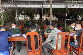 Bộ đội Biên phòng và Công an tỉnh Tây Ninh làm các thủ tục tiếp nhận số lao động tự do tại Campuchia trở về nước. (Ảnh: TTXVN phát)