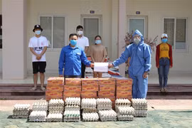 Đại diện Đại sứ quán Việt Nam tại Lào trao quà cho sinh viên Việt Nam đang học tập tại Đại học Quốc gia Lào gặp khó khăn do dịch bệnh COVID-19. (Ảnh: Thu Phương/TTXVN)