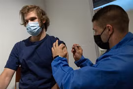 Nhân viên y tế tiêm vaccine ngừa COVID-19 cho thanh niên tại trung tâm tiêm chủng dã chiến ở Paris, Pháp. (Ảnh: THX/TTXVN)