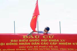 Lắp đặt Panô tuyên truyền tại khu vực bỏ phiếu số 5, xã Mường Giàng, huyện Quỳnh Nhai. (Ảnh: Quang Quyết/TTXVN)