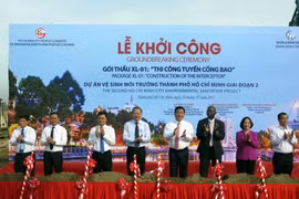 Các đại biểu thực hiện nghi thức khởi công gói thầu XL-01 'Thi công tuyến cống bao' thuộc dự án Vệ sinh môi trường Thành phố giai đoạn 2. (Ảnh: Hoàng Hải/TTXVN)
