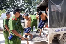 Lực lượng chức năng đưa học viên bỏ trốn về trại tập trung. (Ảnh: Đoàn Mạnh Dương/TTXVN)