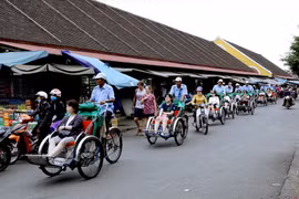 Du khách quốc tế tham quan phố cổ Hội An bằng xích lô. (Ảnh: Quang Quyết/TTXVN)