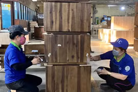 Công nhân Công ty Cổ phần Chế biến gỗ Thuận An kiểm tra các sản phẩm gỗ xuất khẩu. (Ảnh: TTXVN)